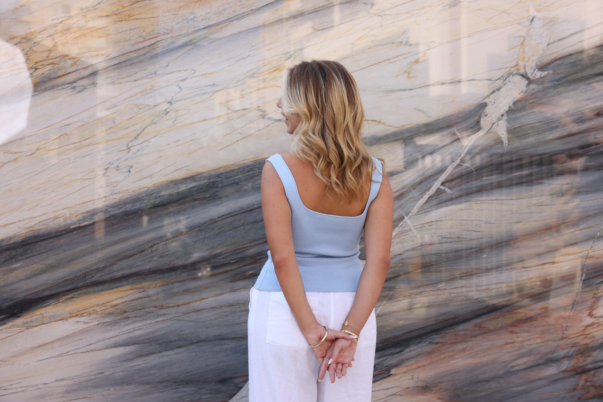 Figure contemplating a dramatic blue-grey marble wall