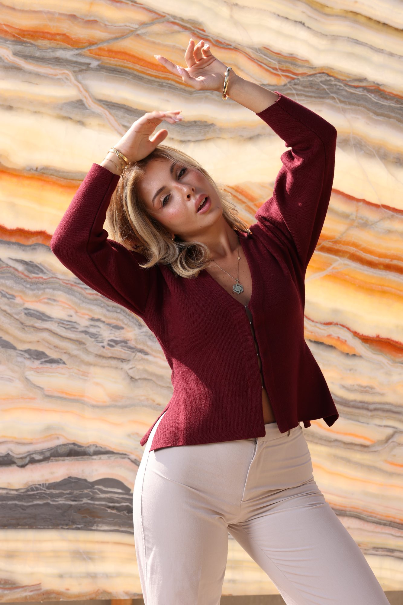 Editorial portrait in burgundy against rich orange onyx veining — Zein Group